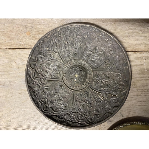 97 - Five metalwares platters, some embossed and carved to centre and rim