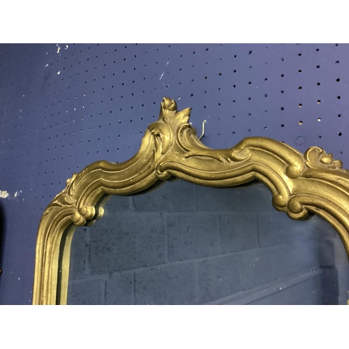 351 - Pair of gilt framed wall mirrors with scrolling borders and finial. Pair including frame 43cm W x 78... 