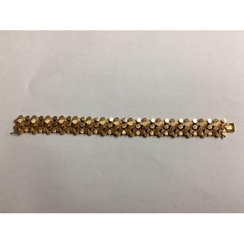 1 - A 9ct gold bracelet of pierced circular textured design. 18cm. 29g.