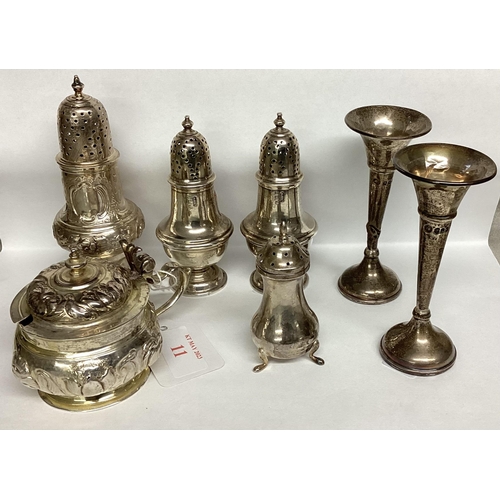 11 - A collection of sterling silver and white metal items to include pepperettes and a pair of trumpet v... 