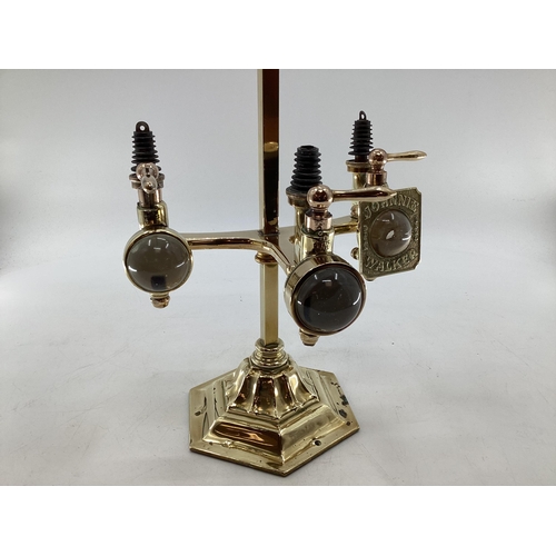 148 - An Edwardian brass free standing three bottle spirit dispenser by Gaskell and chambers, optic pearl ... 