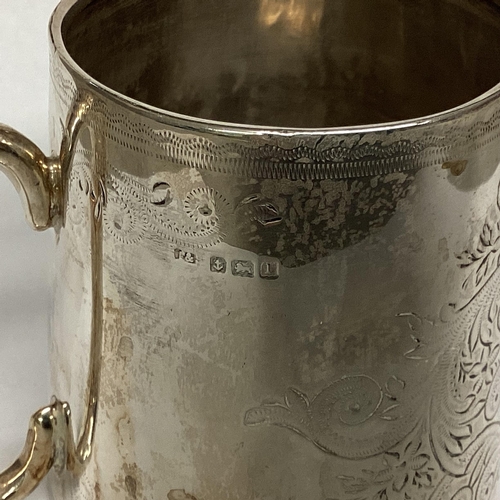 15 - A Sterling silver mug with chased scrolling decoration, loop handle, Birmingham 1910 7.5cmH, 96g