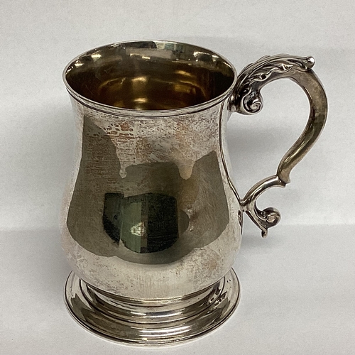 17 - A Sterling silver mug, circular stepped foot and scrolling handle 10cm(h), by Holland Aldwinkle and ... 