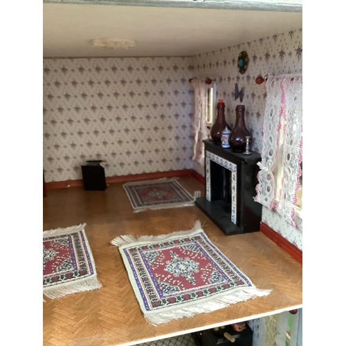 173 - A large well fitted dolls house with numerous accessories and a large quantity of furniture, rugs et... 