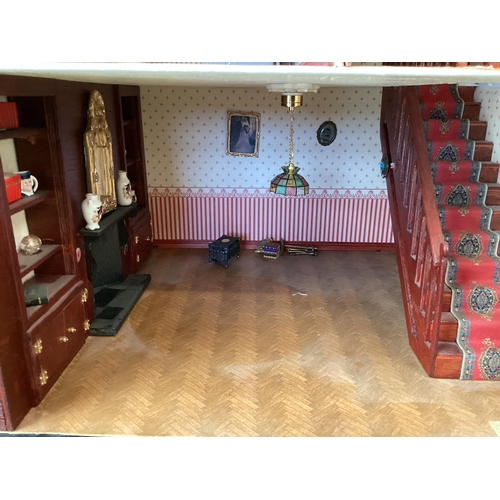 173 - A large well fitted dolls house with numerous accessories and a large quantity of furniture, rugs et... 