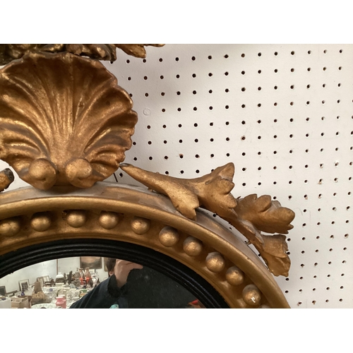 198 - An antique Irish Style, gilt gesso convex circular wall mirror, with ball decoration beneath an eagl... 