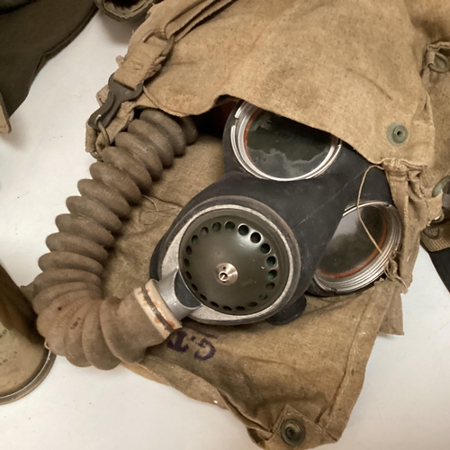 247 - A World War II period military issue long hose gas mask with original haversack and accessories, bro... 