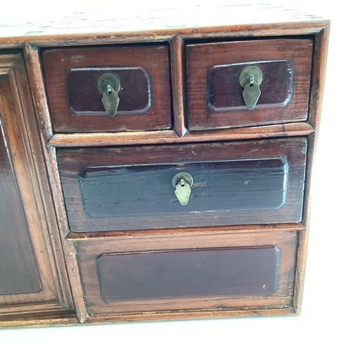 285 - An Early C20th Chinese table top cabinet, two cupboard doors with two long and two short drawers, 56... 