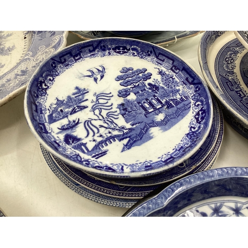 321 - Large collection of blue and white ceramics to include Willow pattern meat plates, bowls etc