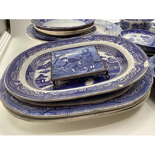 321 - Large collection of blue and white ceramics to include Willow pattern meat plates, bowls etc