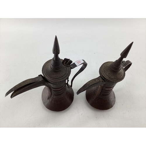 332 - Two middle eastern copper coffee pots with traditional chased design, largest 34cm