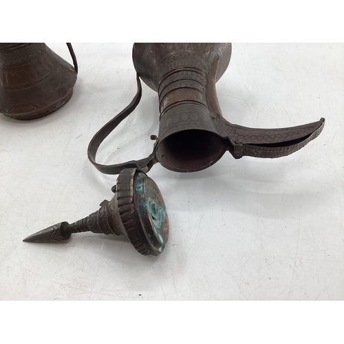 332 - Two middle eastern copper coffee pots with traditional chased design, largest 34cm