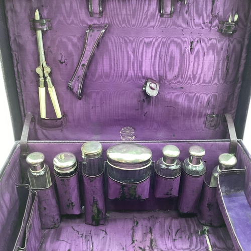 348 - Vintage purple leather travel vanity case with fitted interior containing numerous white metal toppe... 