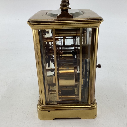 353 - A Swiss gilt brass carriage clock, with visible escapement stamped made in Switzerland 17cm (in hand... 