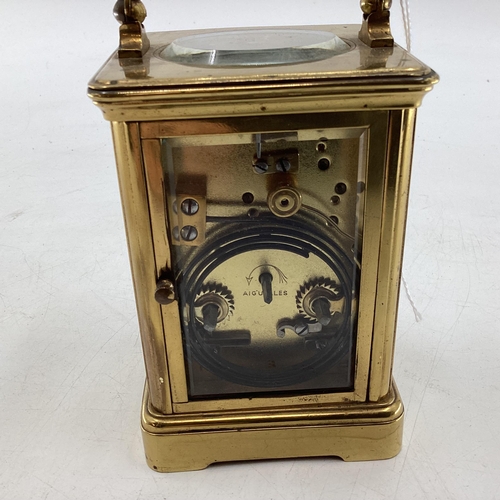 353 - A Swiss gilt brass carriage clock, with visible escapement stamped made in Switzerland 17cm (in hand... 