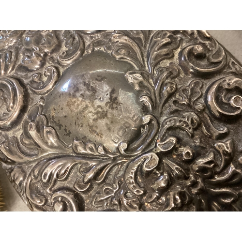 38 - A Sterling silver hand mirror, with Art Nouveau decoration, and three silver mounted brushes of diff... 