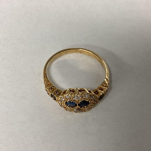 40 - An unmarked yellow metal diamond and sapphire ring two central round cut sapphires with a surround o... 