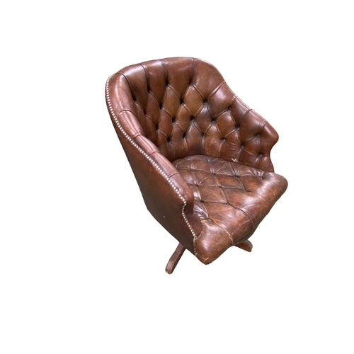 450 - A good Hillcrest swivel tub arm chair in studded button back leather, with serpentine apron on a qua... 