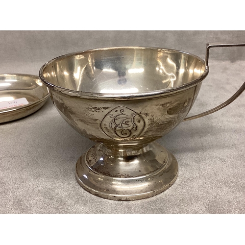 49 - A Sterling silver cup, circular stepped base, loop handle, together with an unmarked white metal pin... 