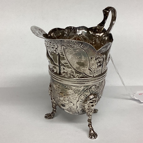 6 - A Sterling silver cream jug, decorated with repousse farmyard scenes on 3 paw feet by John Millward ... 