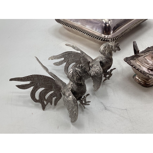 60 - Collection of silver plated wares to include two lidded dishes, salt cellars and white metal rooster... 