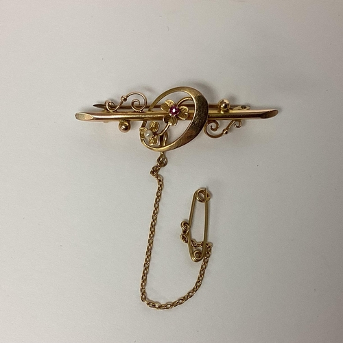 65 - A 15ct gold brooch set with single cut ruby and single pearl 2.67g