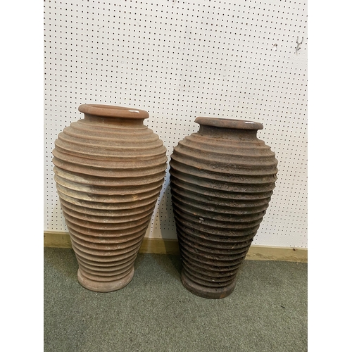 73 - Two similar terracotta tall ribbed hoop pattern urns/pots, 65cm H