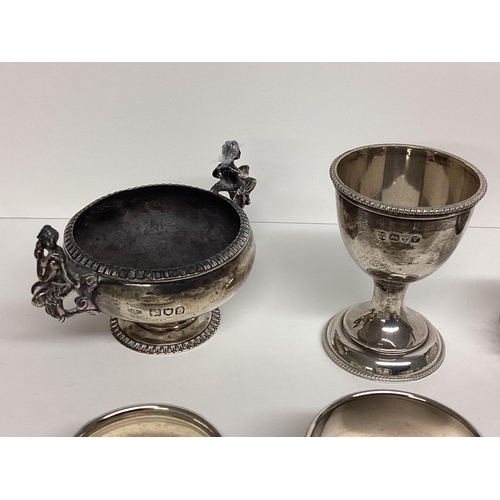 87 - Collection of Sterling silver items to include napkin rings, egg cup, 216g silver, and a silver hand... 