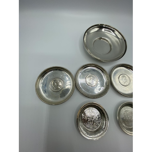 12 - A set of 4 silver coin set pin dishes and a sterling silver example and 2 unmarked white metal Middl... 