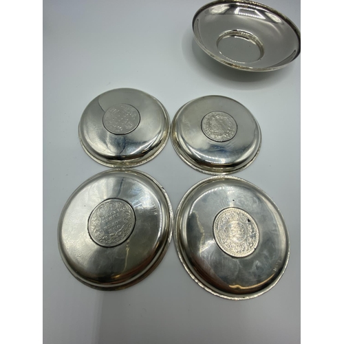 12 - A set of 4 silver coin set pin dishes and a sterling silver example and 2 unmarked white metal Middl... 