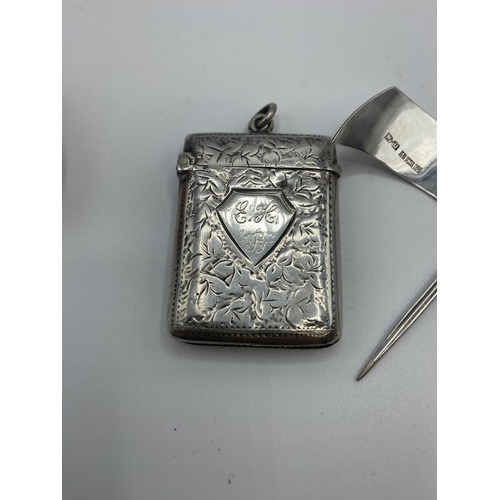 143 - A collection of sterling silver items, to include decanter labels, cheese flags, vesta, and a white ... 