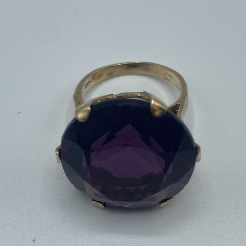 20 - A 9ct gold dress ring, single circular free cut amethyst coloured paste stone in a six claw setting,... 