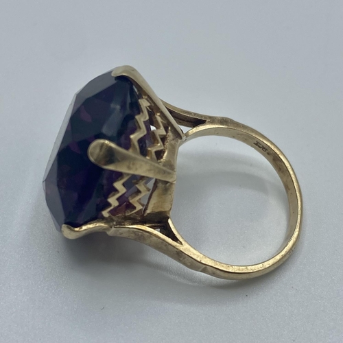 20 - A 9ct gold dress ring, single circular free cut amethyst coloured paste stone in a six claw setting,... 