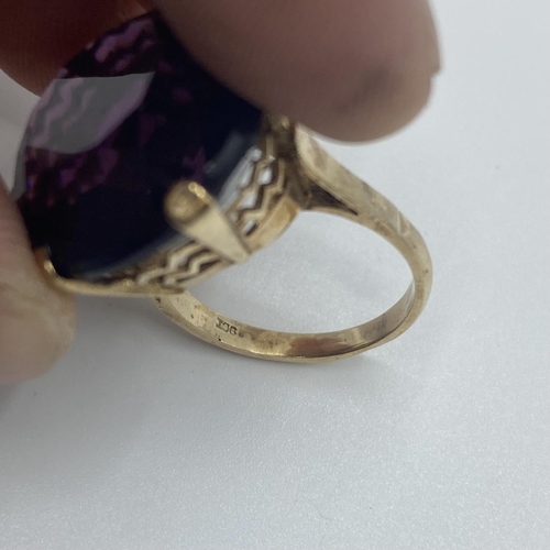 20 - A 9ct gold dress ring, single circular free cut amethyst coloured paste stone in a six claw setting,... 