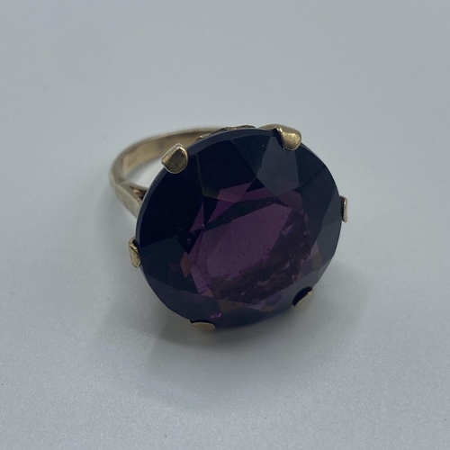 20 - A 9ct gold dress ring, single circular free cut amethyst coloured paste stone in a six claw setting,... 