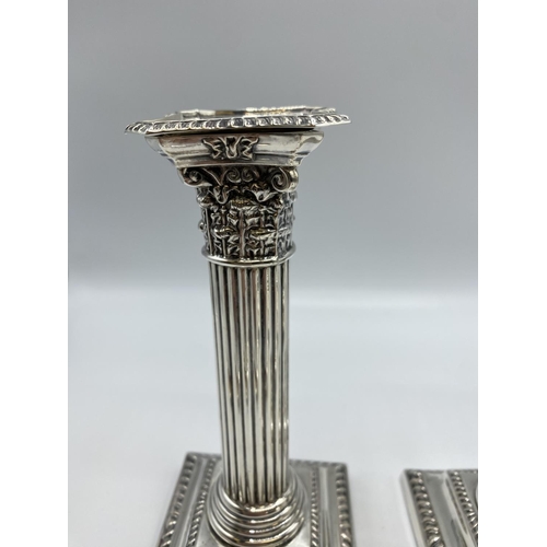 59 - A pair of sterling silver weighted column candlesticks 16cm(h)