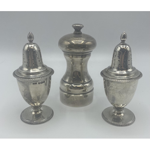 73 - A pair of Adams style pepperettes together with a sterling silver pepper grinder.