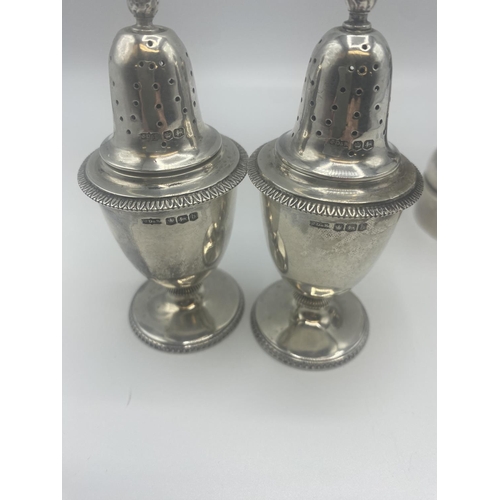 73 - A pair of Adams style pepperettes together with a sterling silver pepper grinder.