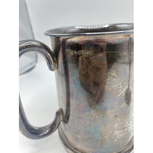 89 - A sterling silver mug with glass bottom. Birmingham 1934. Together with a white metal wine goblet, a... 