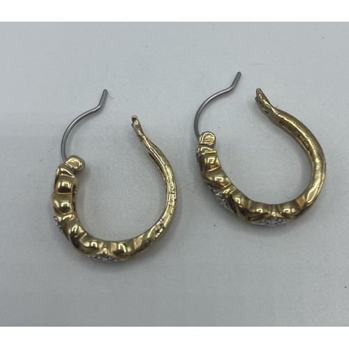 95 - A pair of diamond ear studs together with a pair of yellow metal hoop earrings.