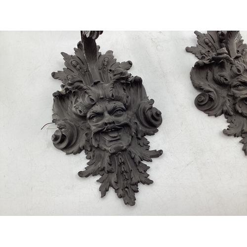 253 - A pair of French C19th Bronze single branch wall sconces cast satyr mask with scrolling Rococo desig... 