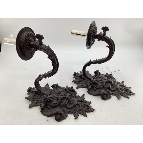 253 - A pair of French C19th Bronze single branch wall sconces cast satyr mask with scrolling Rococo desig... 