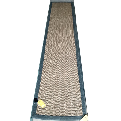 676 - A sisal runner rug, 370 x 75cm, with grey material edging