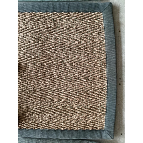 676 - A sisal runner rug, 370 x 75cm, with grey material edging