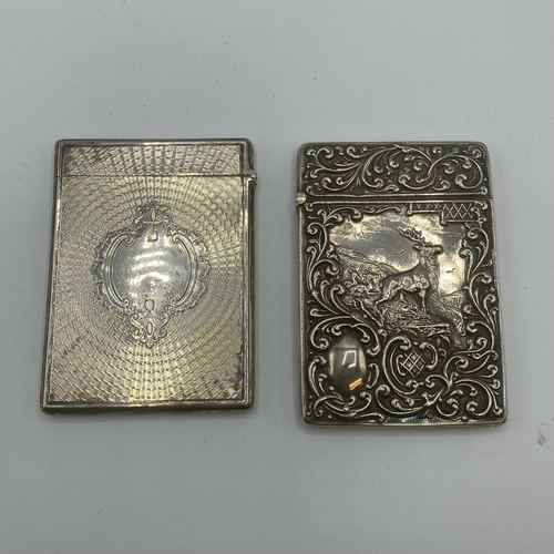 99 - Two sterling silver card cases, one with a stag in a landscape, vacant cartouche, scrolling surround... 