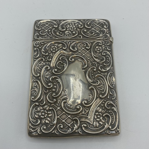 99 - Two sterling silver card cases, one with a stag in a landscape, vacant cartouche, scrolling surround... 