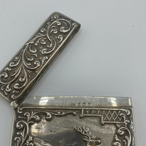 99 - Two sterling silver card cases, one with a stag in a landscape, vacant cartouche, scrolling surround... 