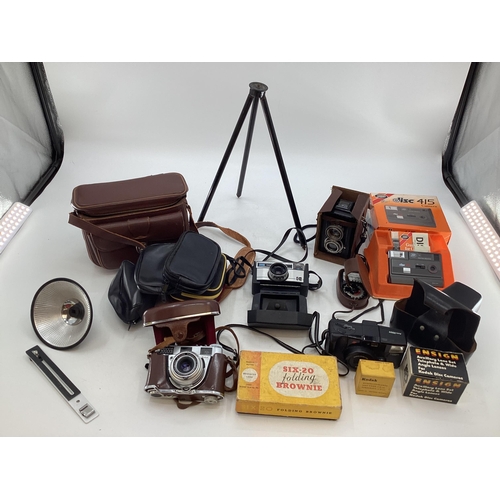 315 - A collection of vintage cameras and equipment to include a Box Brownie and a Kodak Petina