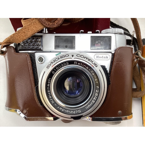 315 - A collection of vintage cameras and equipment to include a Box Brownie and a Kodak Petina