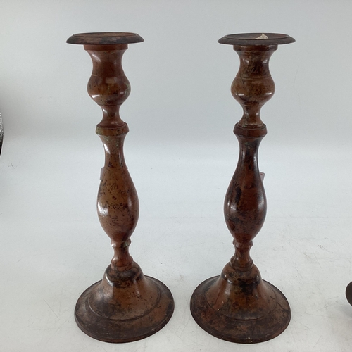 369 - A pair of Indian metal candlesticks together with a carved model of a bird on stand, (Sticks 35cmh)